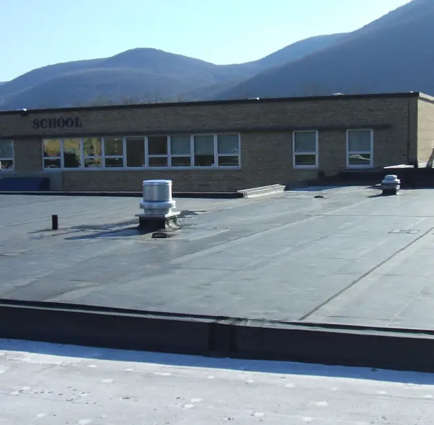 The roof of a school showing vents and a flat roof.