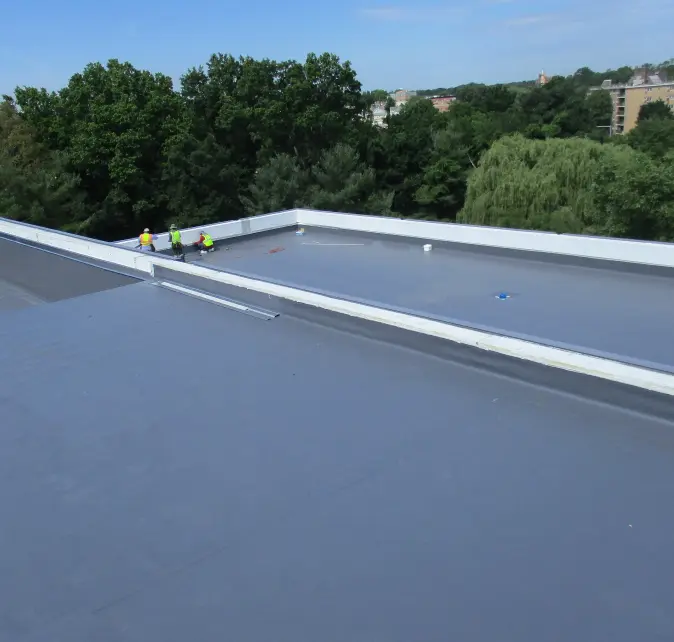 An aerial view of a Vanguard Roofing crew installing a new flat commercial roof.