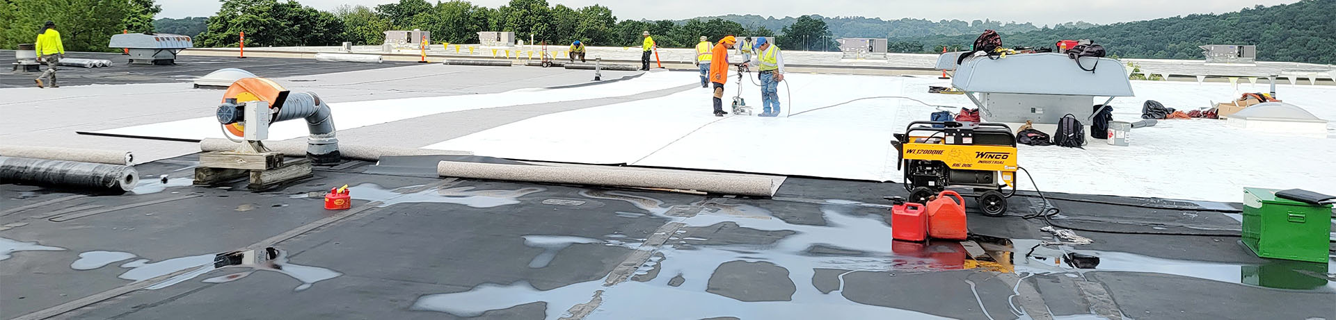 A Vanguard Roofing crew installing a new flat commercial roof in Worchester, MA.