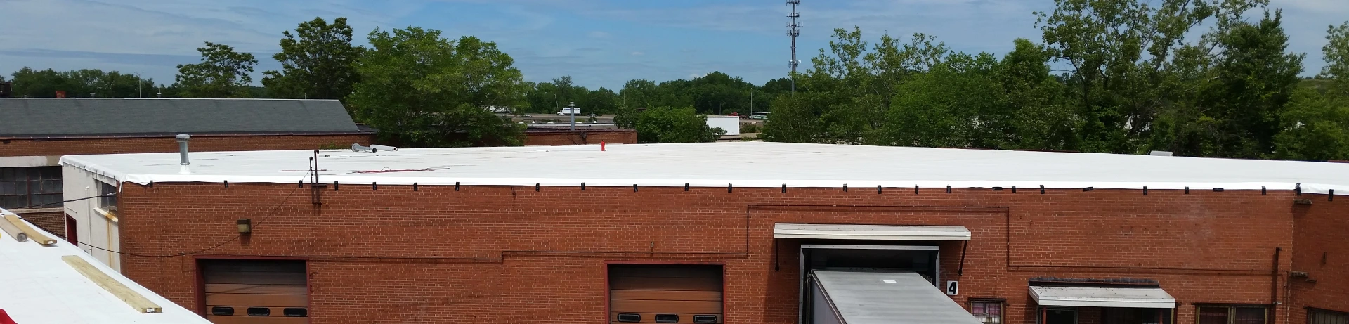 A commercial warehouse with a new reflective coating installed by Vanguard Roofing in Hartford, CT.