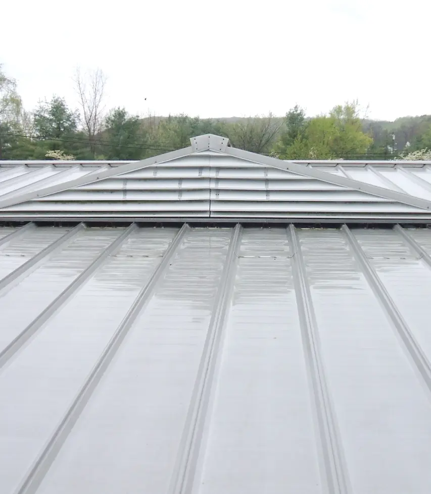 A closeup image of a white commercial metal roof being installed by Vanguard Roofing.
