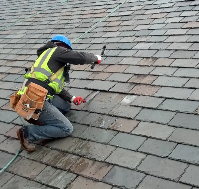 A Vanguard Roofing crew member repairing a slate roof.