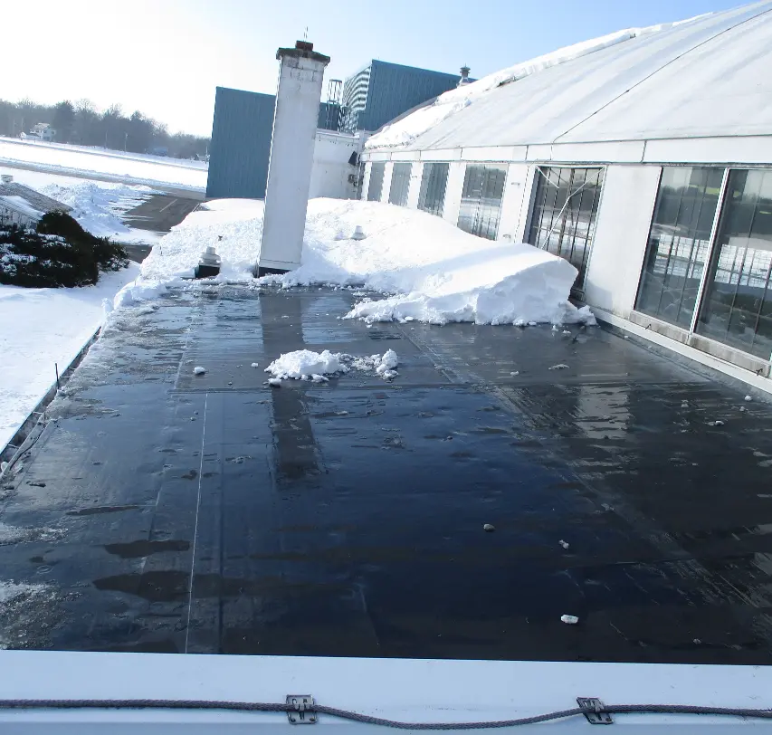 A commercial roof with snow removal in process.