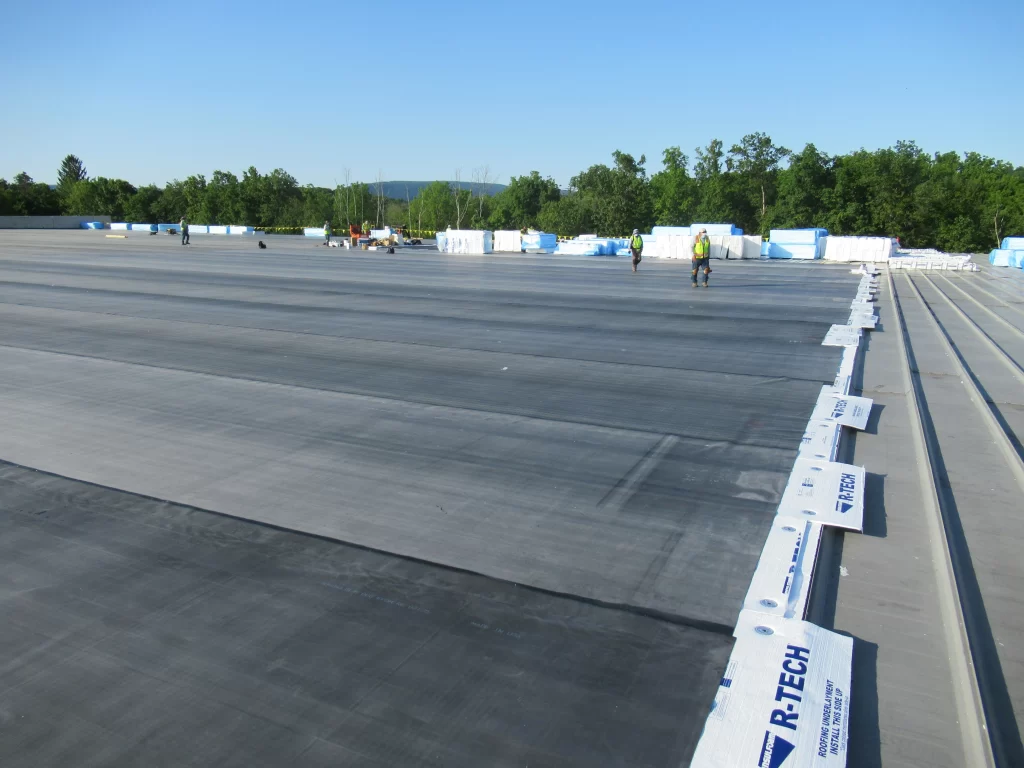 Commercial roof with black membrane installed and R-Tech edge materials visible