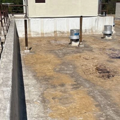 Flat commercial roof with surface discoloration and weather damage