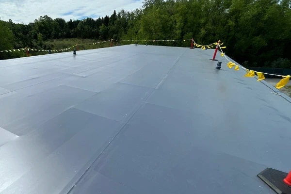 Completed flat roof membrane installation on a commercial facility showing clean seams and proper drainage layout