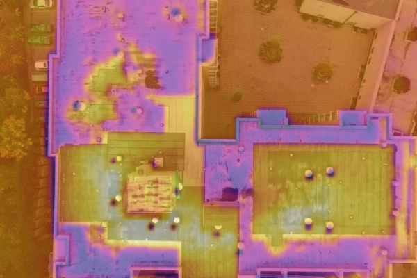 Aerial thermal imaging scan of a commercial flat roof showing moisture infiltration and heat variance used for roof leak detection.