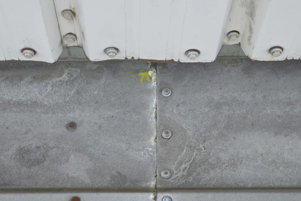 Close-up of a flaw in a seam on a commercial metal roofing panel